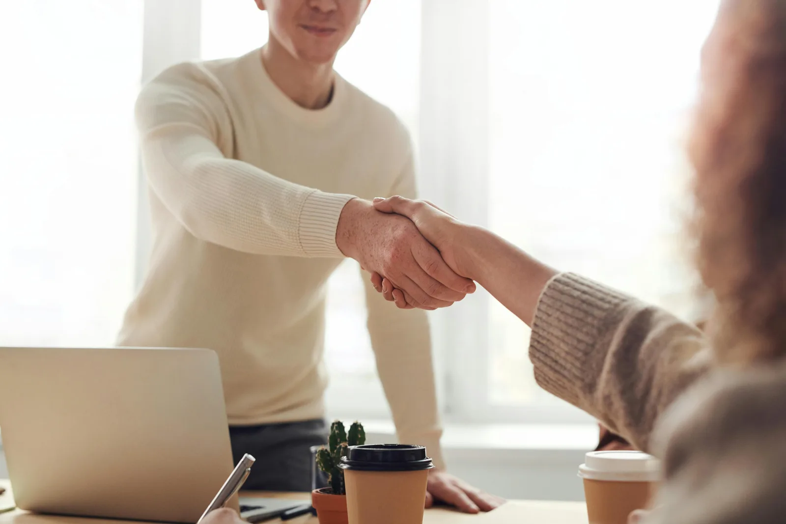 Two people shaking hands representing accountable and governed partnership